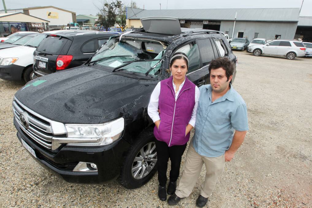 SMASHED: Marcia and Wassim Saliba with the destroyed Toyota Landcruiser. They had bought the $120,000 car only four months earlier. Picture: BLAIR THOMSON