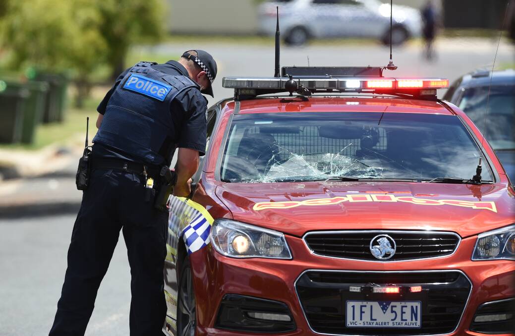 SMASHED: A police officer inspects the broken windscreen. Picture: MARK JESSER