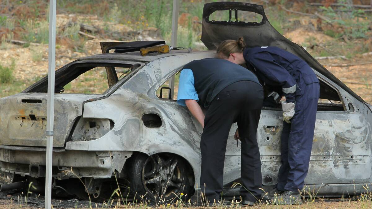 INVESTIGATION: Forensic officers examine a burnt out car at Halls Road in Myrtleford on Thursday. Picture: BLAIR THOMSON