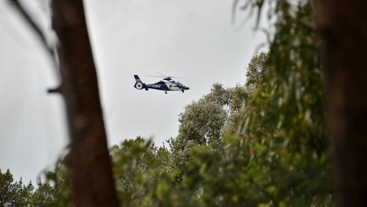 RESCUE OPERATION: A police helicopter searches above the family's property. Picture: BLAIR THOMSON