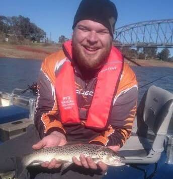SUCCESS: Adam, from Wodonga, was all smiles after bringing in a 45cm brown trout during a recent fishing expedition to Lake Hume.
