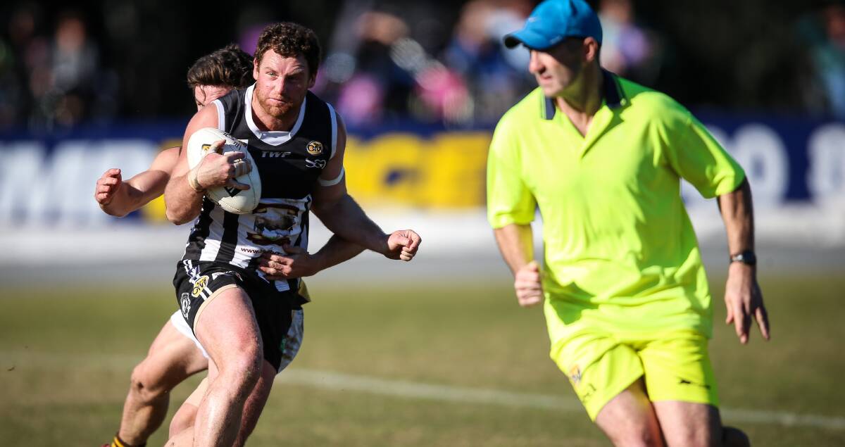 HOT PIES: Wangaratta Hall of Famer Jon Henry takes evasive action in his role as runner while Daniel Boyle is tackled. Picture: JAMES WILTSHIRE