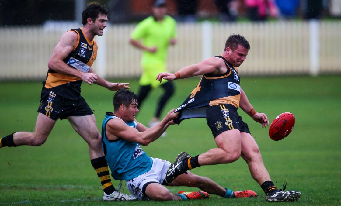 GOTCHA: Tiger Alex Goodall just gets a kick away as he is tackled by Panther Jacob Way at the Albury Sportsground. Picture: JAMES WILTSHIRE
