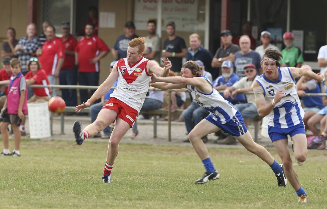 RED, WHITE AND BROWN: Chiltern's Mason Brown boots the Swans forward in Saturday's 123-point victory against Yackandandah. Picture: ELENOR TEDENBORG