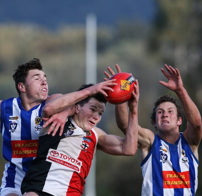 LACH IT IN: Myrtleford forward Lachlan Dale takes a strong mark against Corowa-Rutherglen defenders Shaun Turvey and Cody Kuschert on Sunday. The Saints won the contest at McNamara Reserve by 95 points. Picture: MARK JESSER