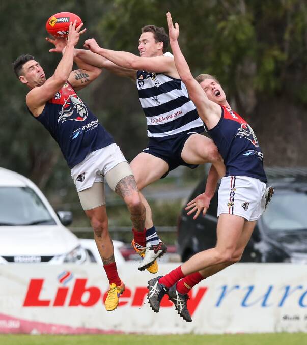 CRACKING CONTEST: Yarrawonga star Marcus McMillan flies between Wodonga Raiders Dean Giles and Zach Rouse in Sunday's first semi-final, which the Pigeons won by five points, at John Foord Oval. Picture: MARK JESSER