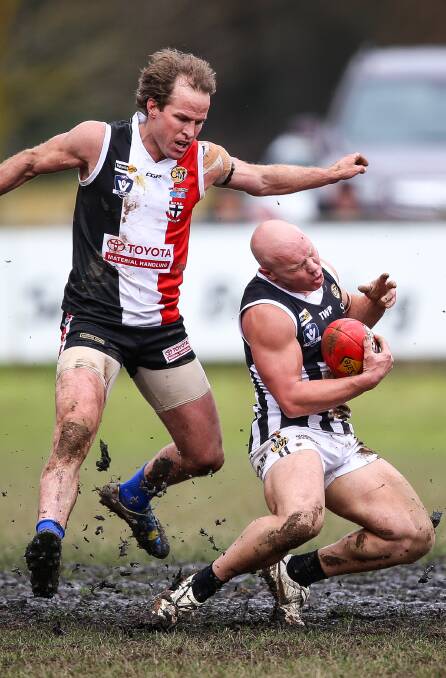 FIERCE CONTEST: Myrtleford co-coach Brad Murray catches Magpie Matt Kelly high in Saturday's match in boggy conditions at McNamara Reserve. Pictures: JAMES WILTSHIRE