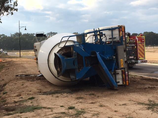 CONCRETE IN A HARD PLACE: A heavy haulage tow truck was brought into White Box Rise to remove the loaded concrete truck. The vehicle was travelling through a new housing estate when it tipped over. Picture: NINE NEWS