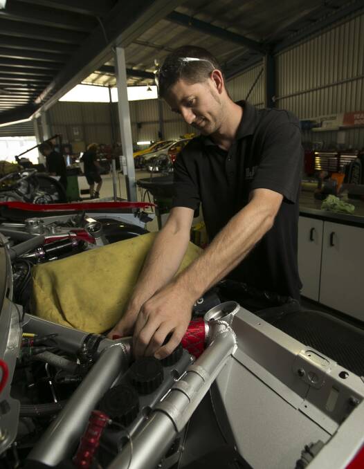 WE CAN FIX IT: Sam Cosgrove works on Tim Slade's Freightliner Holden ahead of the V8 Supercars season. Pictures: ELENOR TEDENBORG