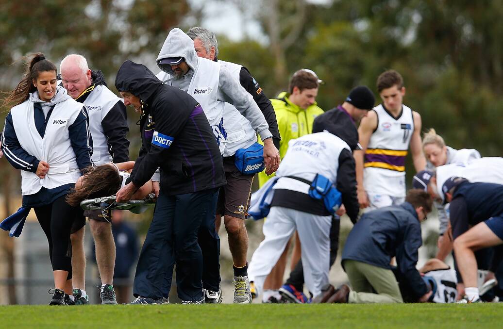 BATTERED BUSHIES: Murray Bushranger Lachie Tiziani is stretchered off as trainers treat teammate Damon Hemphill at Craigieburn on Saturday. Pictures: GETTY IMAGES