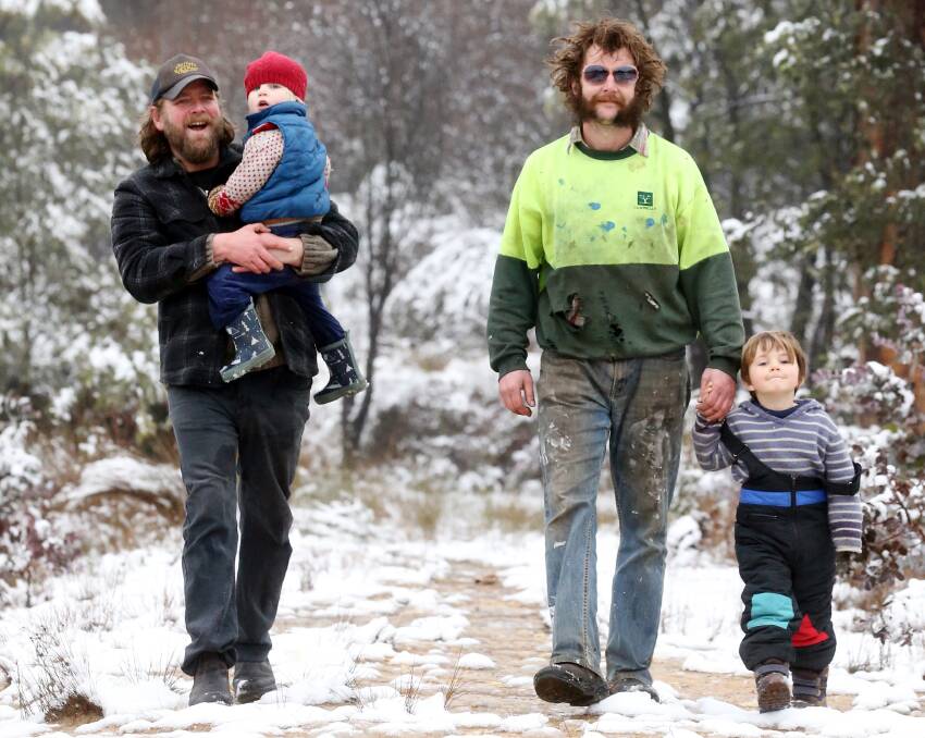 Taking it all in: Dan Saunders and his son Otis, 2, and Warren Ferres with his son Arlo, 4, go for a walk in the snow-covered landscape.