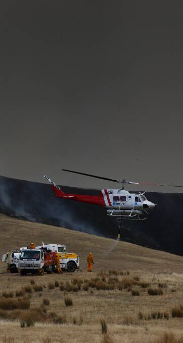 Never stopped: Aircraft including this helicopter assisted a large contingent of firefighters drawn from across the region in tackling the fire. Pictures: MARK JESSER