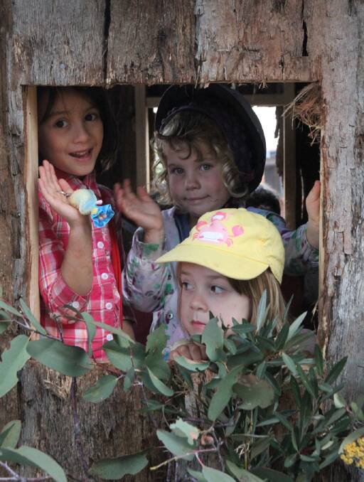 HI THERE: Sinta O’Donnell, Layla Snowden and Stella Danks wave from inside the Wandiligong Primary School hut float, the overall parade winner. Picture: GRAHAM GALES