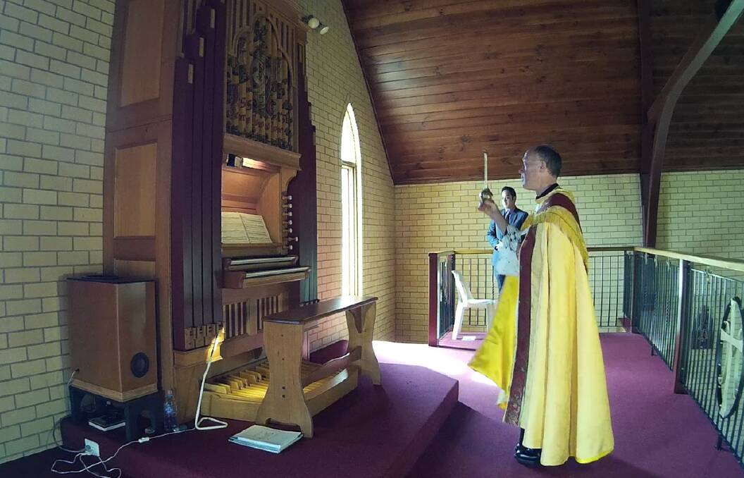 SPECIAL MOMENT: Father Peter Murphy prays over the new organ at St Mary's Catholic Church, Jindera, before its inaugural recital on Sunday.