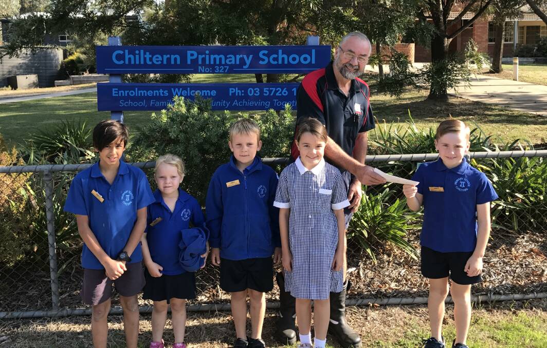 RECEIVED WITH THANKS: Members of Chiltern Primary School's junior school council present the Easter fair proceeds to Chiltern CFA treasurer Geoff Perry.