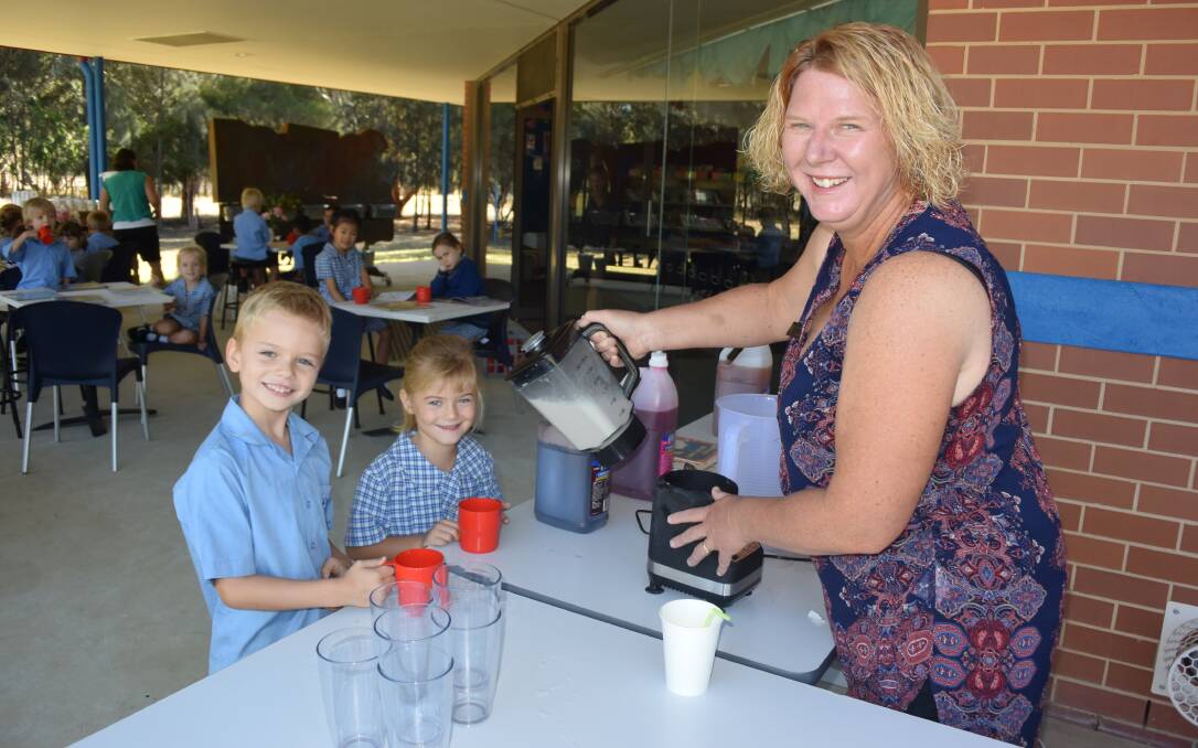 ANTICIPATION: St John's kindergarten students Levi Wilson and Stella Sargeant, both 5, receive a milkshake from their teacher Fiona Schulz in the library cafe.