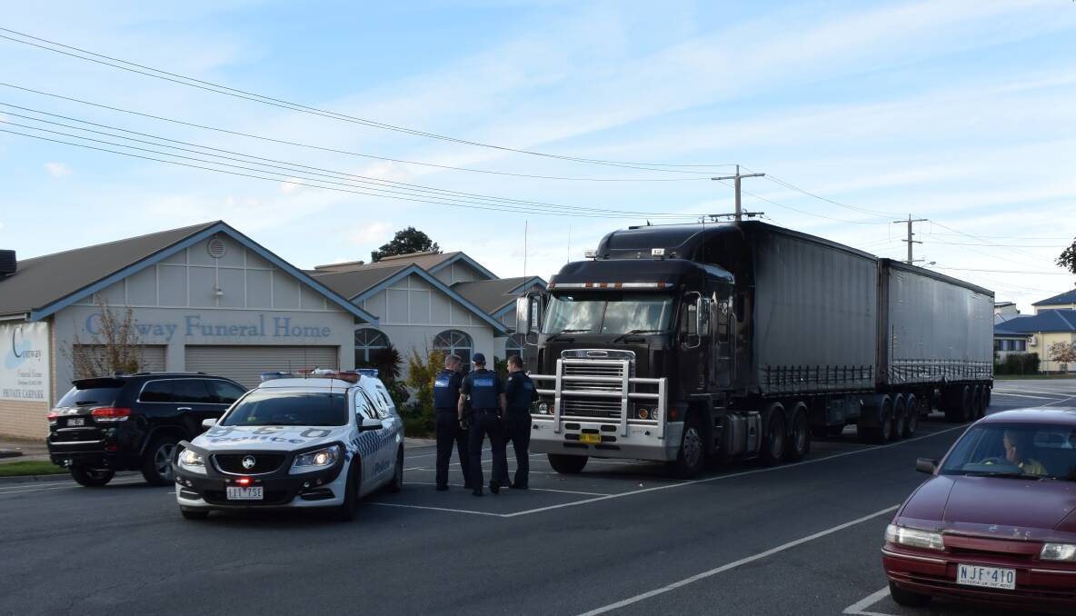 QUESTIONS: Wodonga police talk to the driver of a truck intercepted in South Street on Saturday.