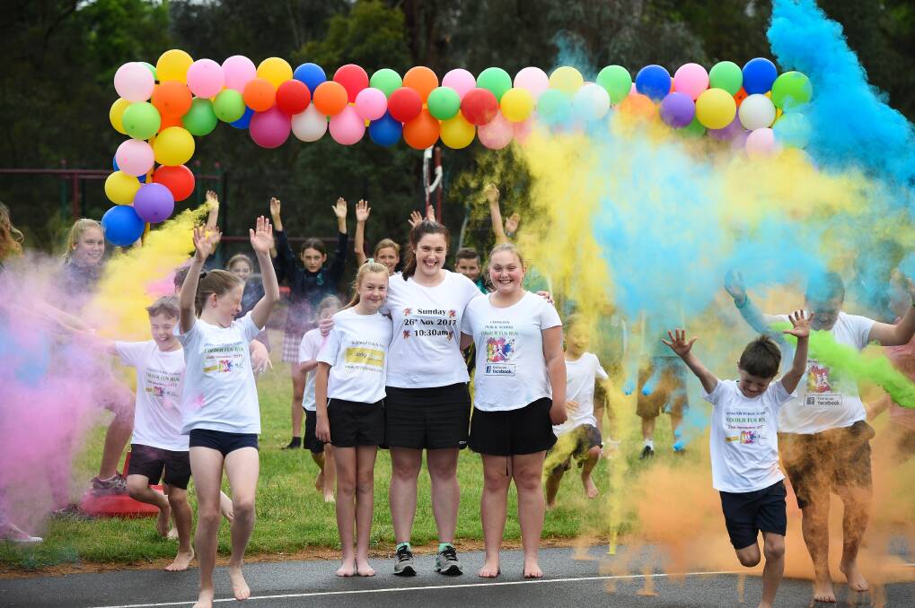 EXCITEMENT BUILDS: Lavington Public School year 6 student Morgan Pritchard, 12, teacher Kristen Guymer and Sophie Barnes, 12, also year 6, get a taste of the atmosphere expected during a colour fun run. Picture: MARK JESSER