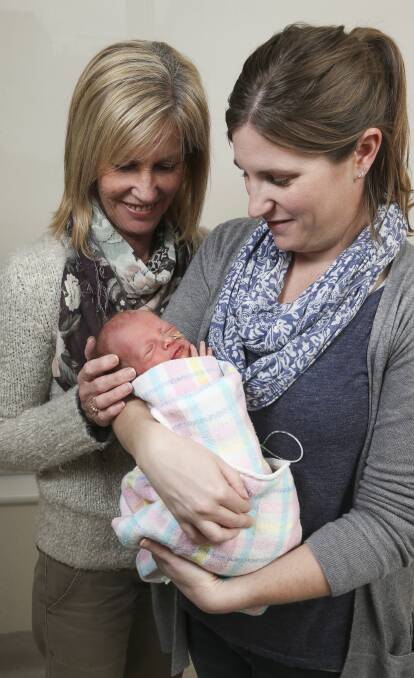 NEXT GENERATION: Debbie Ferrara and Jontelle Scholz cuddle baby George, proud their late husband and father John Woodman is honoured. Picture: ELENOR TEDENBORG