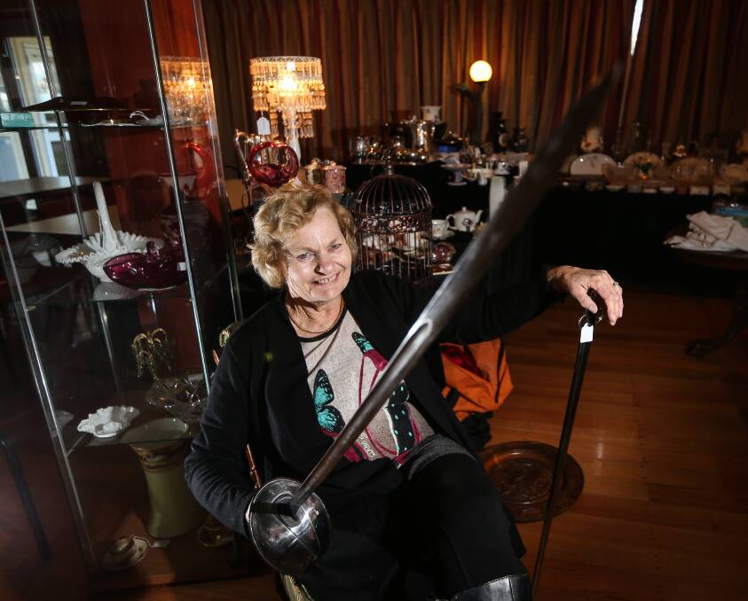 SWORD PLAY: Exhibitor Carol Dennis, of China Bound, holds a 1907 light horse sword as she prepares for this year's Chiltern Antique Fair. Pictures: JAMES WILTSHIRE