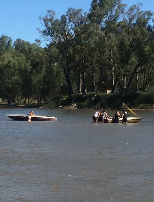 ACTION NEEDED: Some willing helpers band together to free a couple of boats that have become stuck in the Murray River downstream of the Yarrawonga Weir.