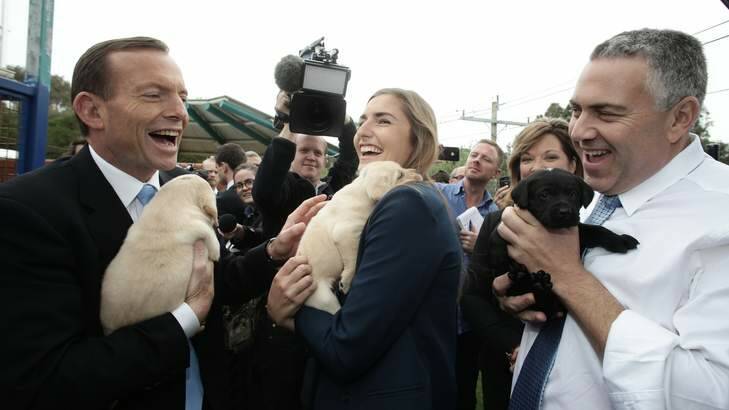 Opposition Leader Tony Abbott looks optimistic ahead of the polls during his visit to Guide Dogs Victoria with his daughter Frances Abbott, and shadow treasurer Joe Hockey. Photo: Alex Ellinghausen