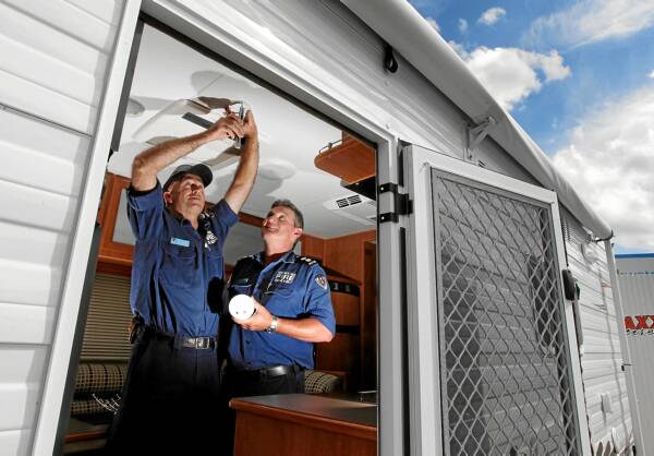 Albury Central firefighters Roger Ghiggioli and Simon Huggett install a smoke alarm, as now required by law, in a caravan. Picture: KYLIE GOLDSMITH