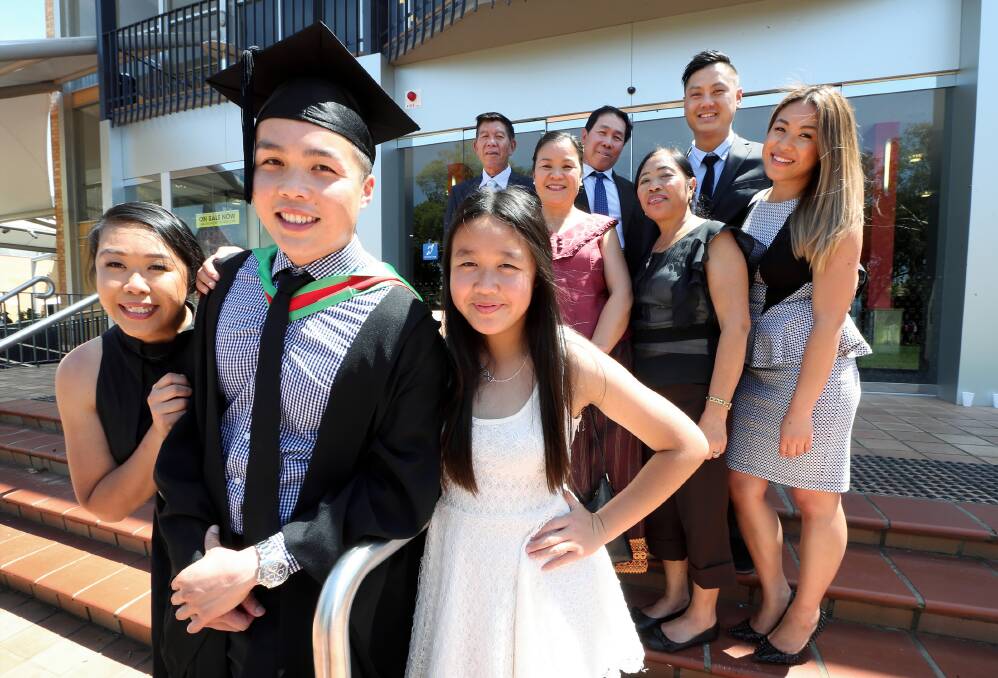 Education graduate Lay Phommachanh, 25, poses with his sisters Sandy, 22, Aaliyah, 12, and the rest of his family who are originally from Laos.