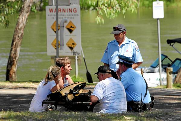 Police and Maritime Service officers interview the couple after they were rescued from the river. Pictures: MATTHEW SMITHWICK