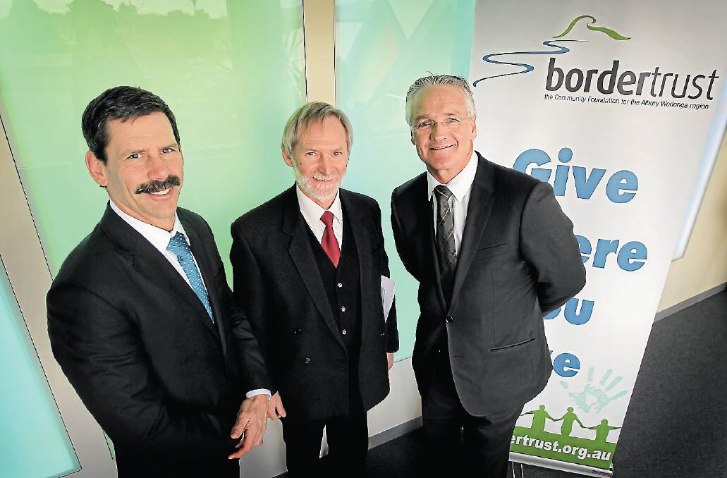 Victorian MP Damian Drum, right, was delighted to hand a bonus $200,000 to Andrew Saxby, representing Border Trust supporter the Hume Building Society, and trust chairman Cr Vic Issell. Picture: TARA ASHWORTH
