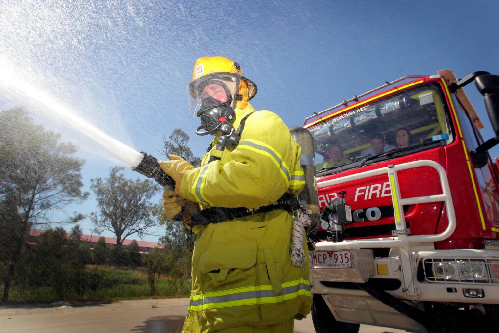 Firefighter Gordon Slattery tests some of his brigade’s gear as Wodonga West first lieutenant Ross Coyle and ANZ’s Conor Noonan and Colleen Leahey watch from the truck. Picture: DAVID THORPE