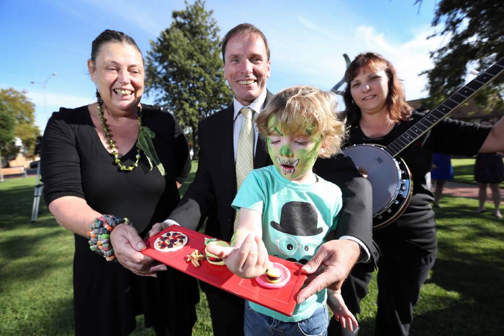 Artist Michelle Oxlee and Charity Watkins, from MEGAS Music, give Henry Keene, 2, of Wodonga, and mayor Rod Wangman a preview of today’s street festival. Picture: MATTHEW SMITHWICK