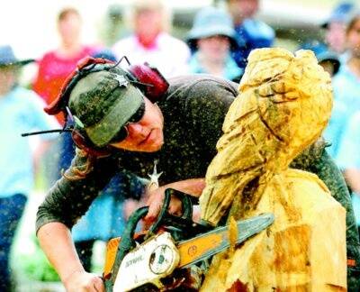 l Champion chainsaw power carver Angela Polglaze carves an owl during a demonstration at Walwa Primary School on Monday. Picture: NIC GIBSON