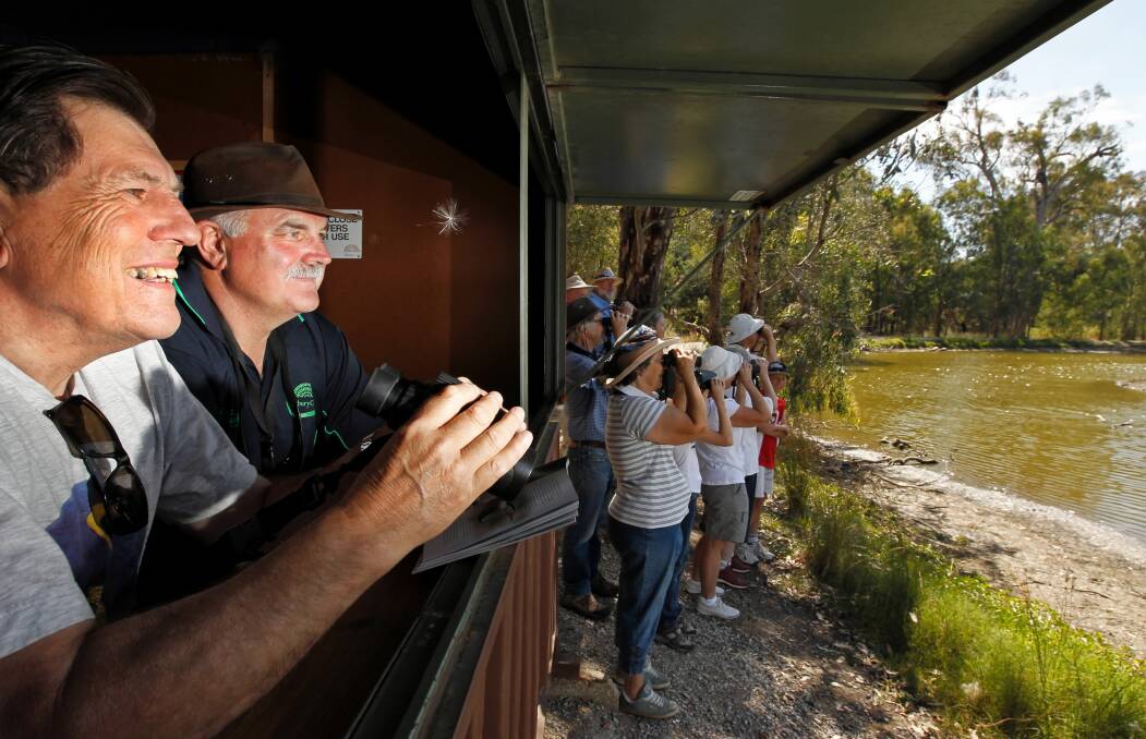 Avid “birder” John Saw and Wonga Wetlands’ John Hawkins take in the view from one of Wonga’s hides while other Albury-Wodonga Birdwatching Society members take their chances outside. Picture: BEN EYLES