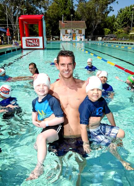 Jayden Forge and Daniel Ryland, both 4, get to know Olympic silver and bronze medallist Eamon Sullivan at the Corowa pool yesterday. 