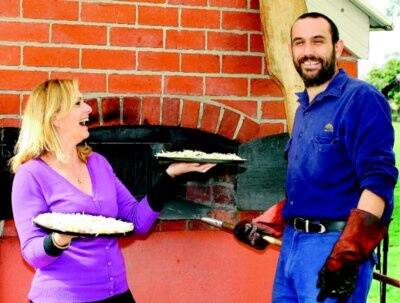 Celebrity chef Janelle Bloom asks community oven co-ordinator Michael Laubli to check the quality of her pizzas before they’re pushed in for baking. Bloom was in town for the Write Around the Murray festival. Picture: RAY HUNT