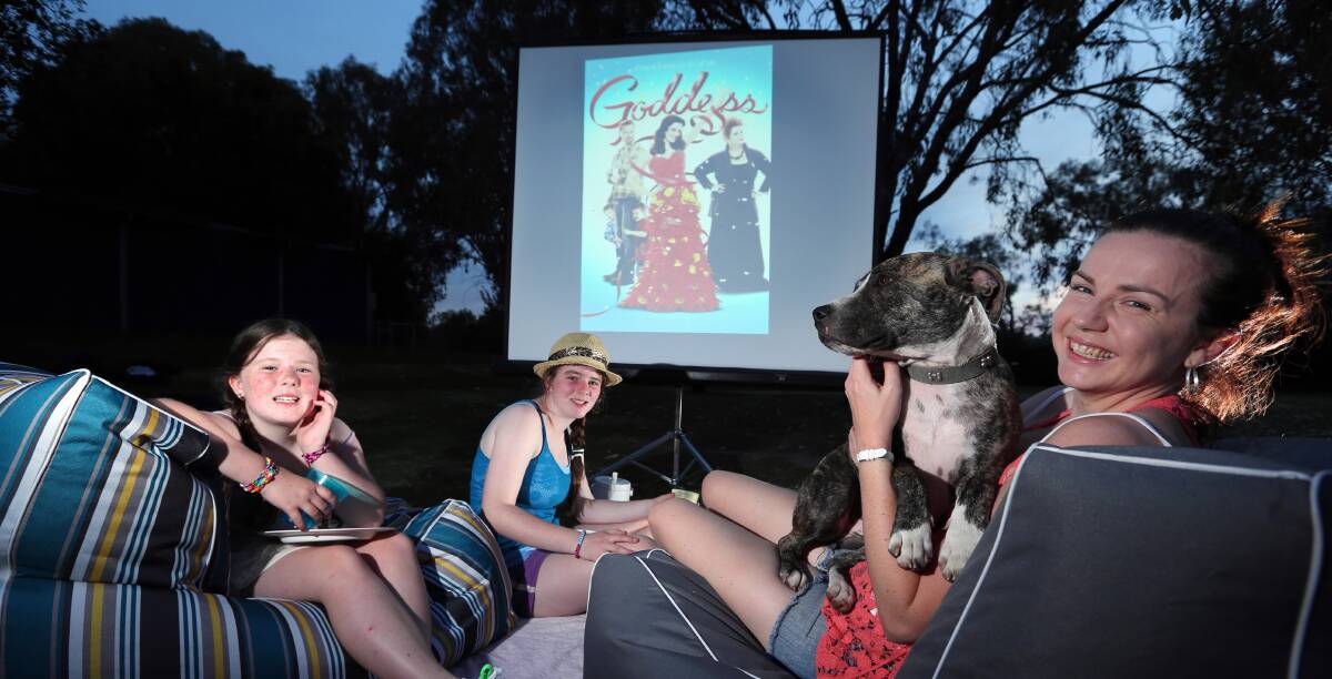 Sisters Rhiannon, 8, and Gabby Head, 12, dog Brutus, and owner Cassie Storm, all of Albury, prepare for Cinema Under the Stars. It returns tonight at Oddies Creek Park with a screening of Goddess. Picture: MATTHEW SMITHWICK