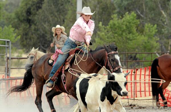 Ready for the next rodeo: Rylie Atkins, 17, on Wacey, lassoes a calf, being watched by her mother, Debbie on Louie. Picture: PETER MERKESTEYN