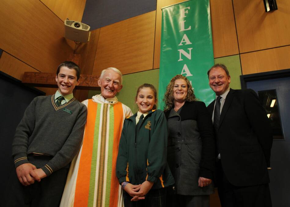 The new “Flanagan House” banner is the backdrop for St Anne’s school captains Jack Mitsch and Jacynda Carmichael, Father Flanagan, acting principal Cassandra Jones and consultant Bede Hart at yesterday’s school celebrations of Father Kevin’s anniversary. Picture: MARK JESSER