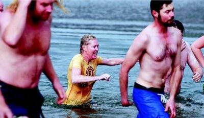 Alison Caller makes her run back to land after braving the five-degree waters of Rocky Valley Lake.