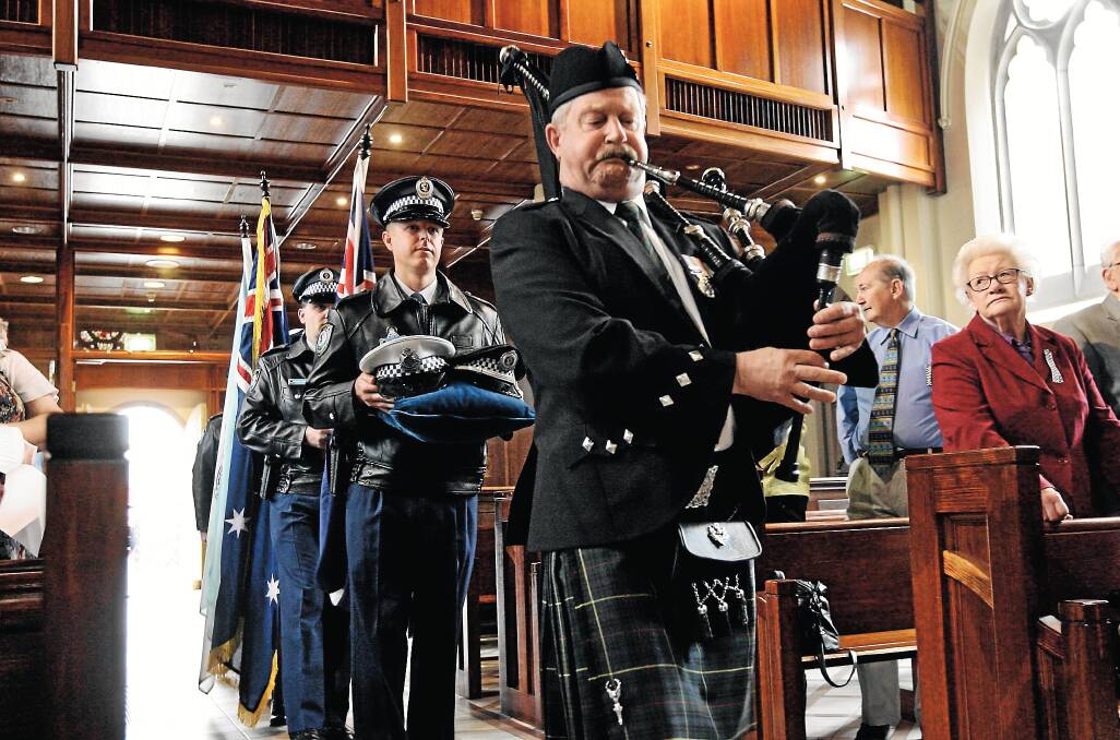 Hat-bearer Constable Tim Wade-Ferrell follows piper Roger Buck into St Matthew’s, Albury, yesterday before the emotional service honouring those who have served in our police forces. Pictures: BEN EYLES