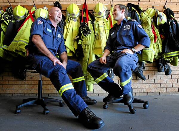 l Firefighters Roger Ghiggioli and Dale Gillespie discuss their rescue of a locket from the Hungry Jack’s fire. Picture: KYLIE GOLDSMITH