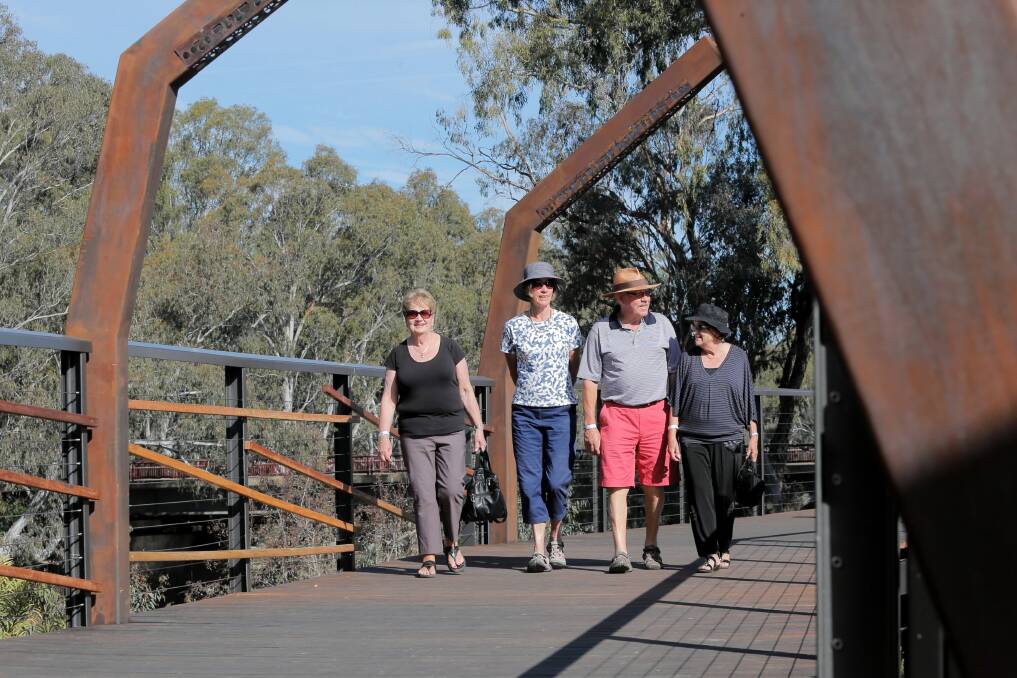 Norma Hughes, of Deniliquin, Margaret Craik, of Wodonga, Tom Rilen, of Wodonga, and Margaret Paynter, of Albury, enjoy a stroll along the boardwalk during the official opening of the Ovens River precinct yesterday. Picture: TARA GOONAN