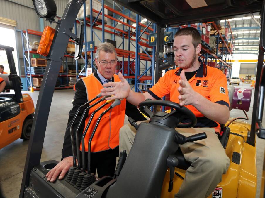 Jake Macklan takes skills minister Peter Hall through the fundamentals of operating a forklift. Picture: PETER MERKESTEYN