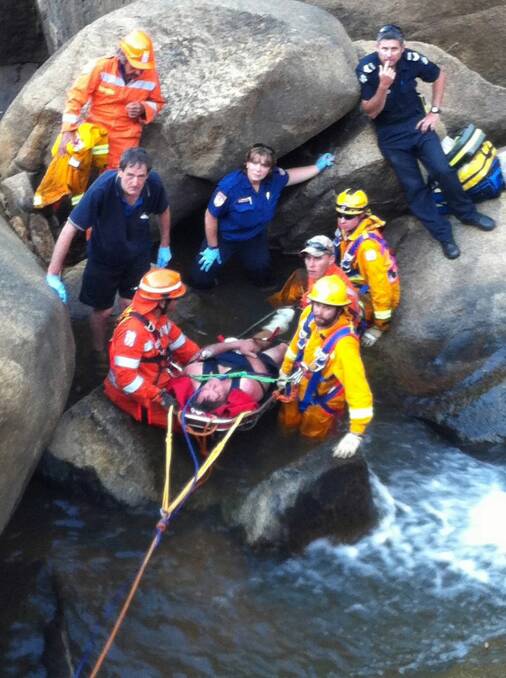 Rescue workers attempt to help the boy off the side of the cliff. 
