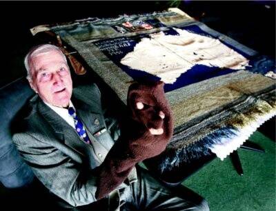 Jim Simpson with a rug and balaclava he used while serving in World War II. Picture: NIC GIBSON