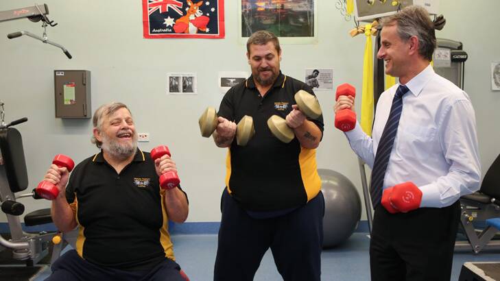 Bend, stretch and lift: Dr Nic Kormas, right, helps patients, Brian Aitken, left, and Steven Parish at Camden Hospital's specialist gym. Photo: Anna Kucera