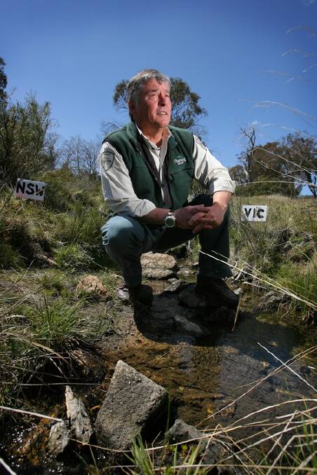 Parks Victoria ranger David Foster straddles the Murray River at Cowombat Flat.