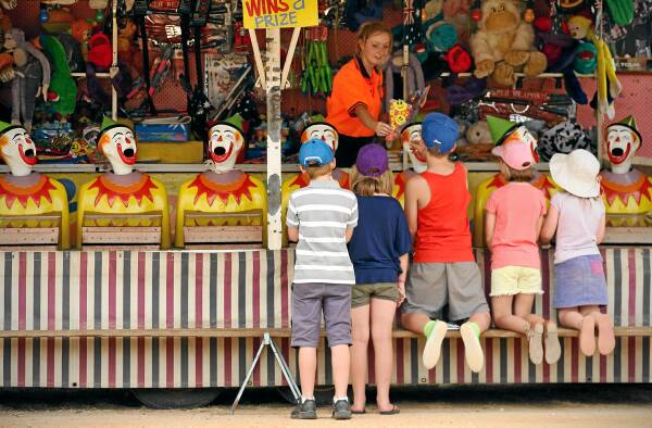 What’s a country show without sideshow alley? Grainne Carroll, of Ireland, passes a prize to children playing the clowns.