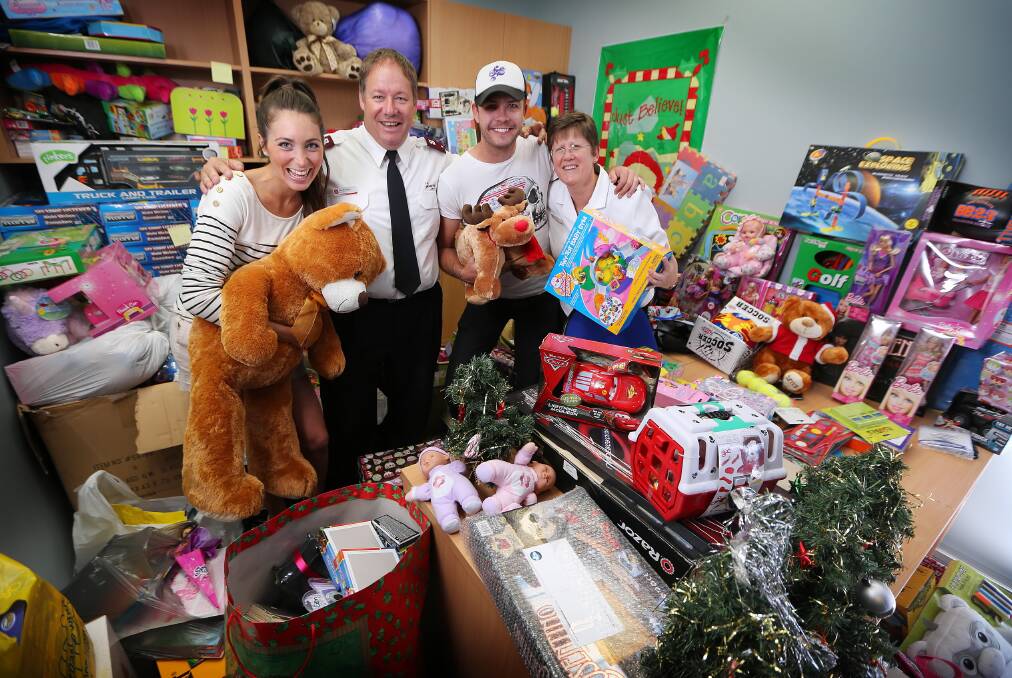 Star FM breakfast announcer Kristie Mercer, with Albury Salvation Army lieutenant  Rod Parsons, fellow announcer Ben Erbsland  and Albury Salvation Army lieutenant Deb  Parsons in front of the large pile of donated gifts. Picture: John Russell 